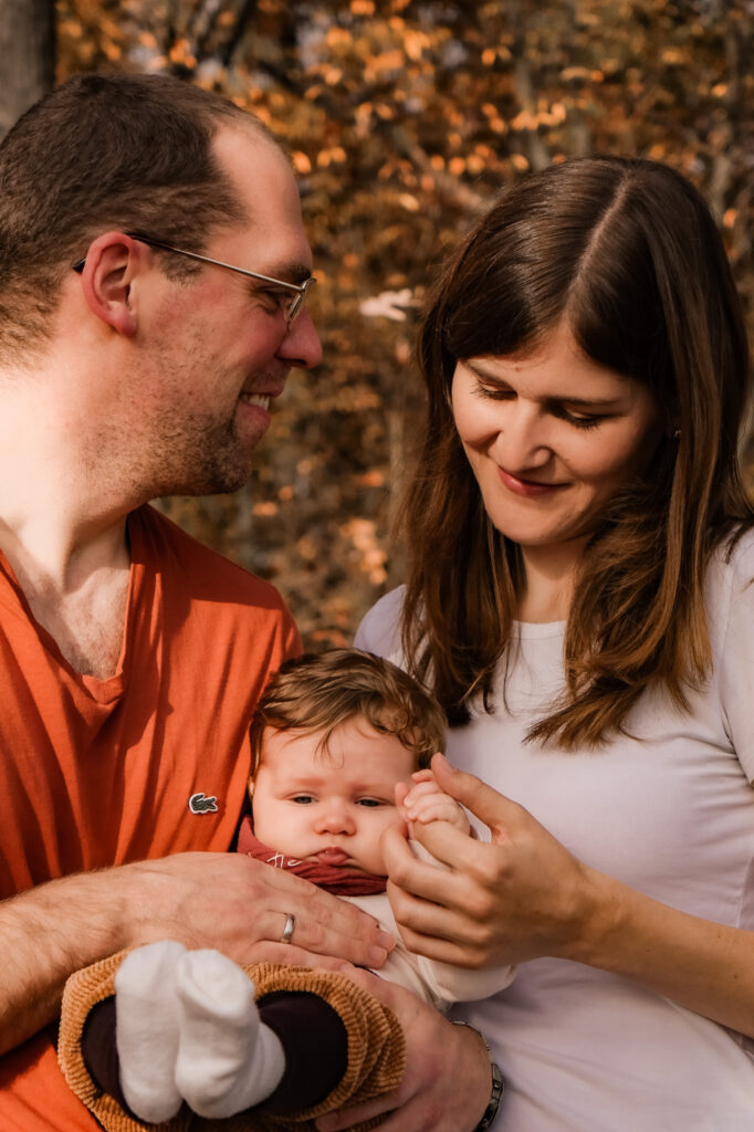 Foto Eltern betrachten Baby auf dem Arm, © A-Line-Photography Aylin Trautter